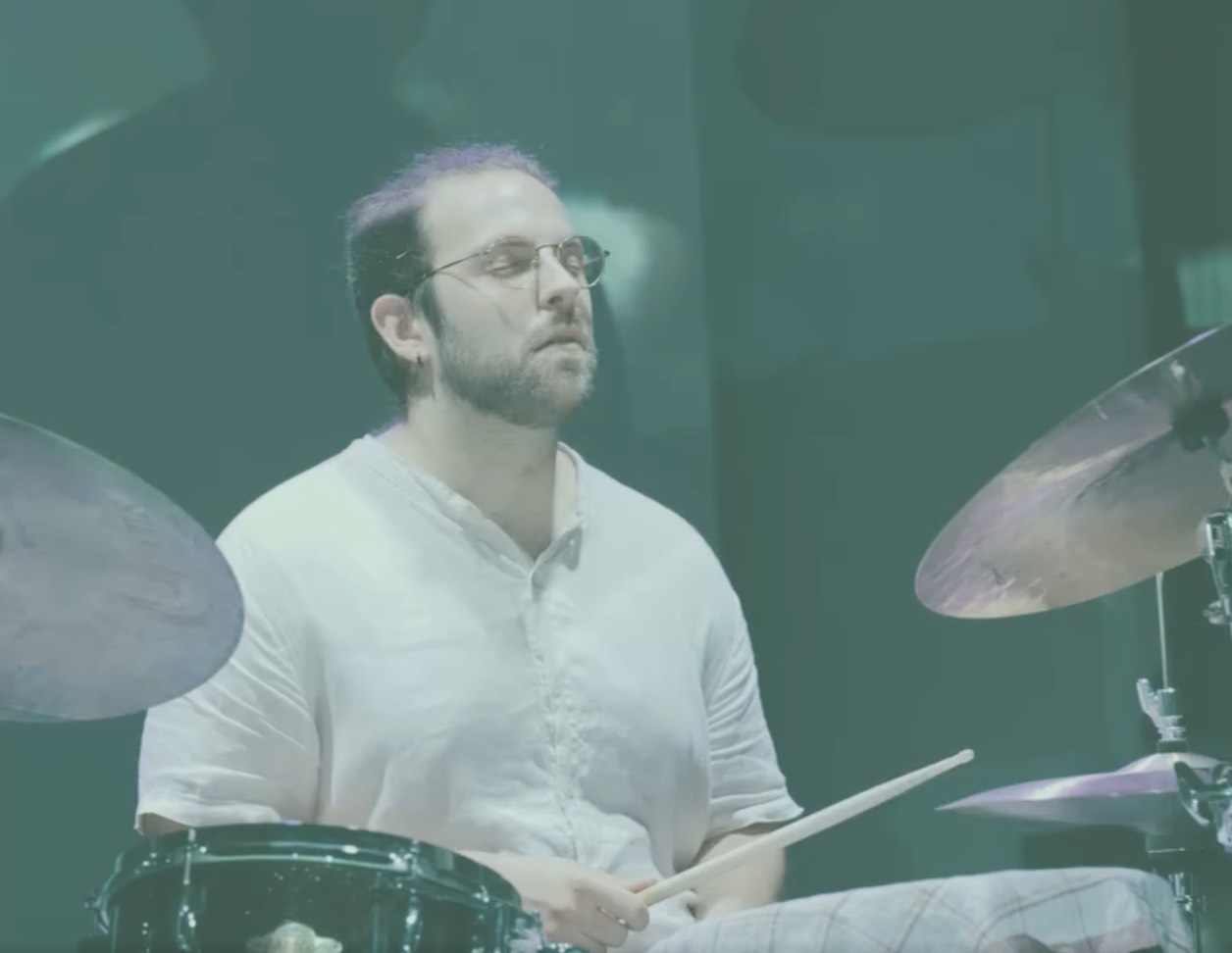 A person drumming on stage.