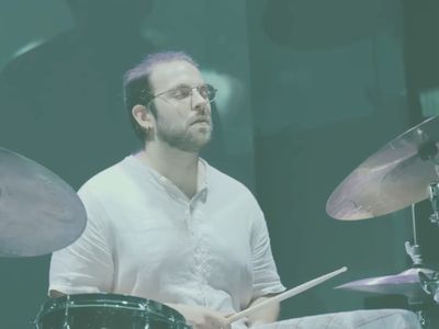 A person drumming on stage.